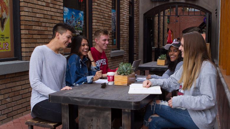 澳门威尼斯人app下载大学的学生们坐在加州奥兰治老城的一家餐馆外面