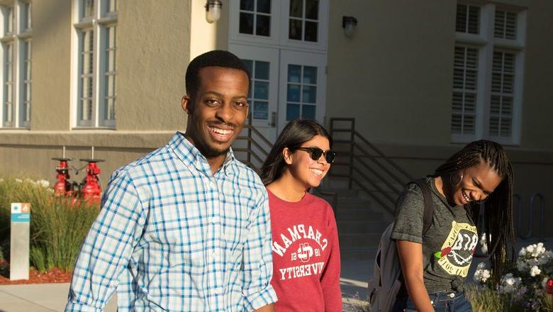 Three students walk on campus